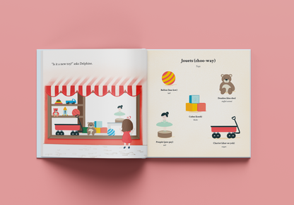 book open to a spread with a toy store scene and toys accompanied with labels in french and english with french pronunciations